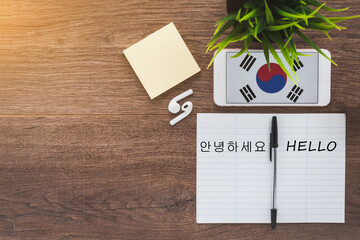 Republic of Korea flag on smartphone on a wooden table, notebook and pen, study concept, text hello...