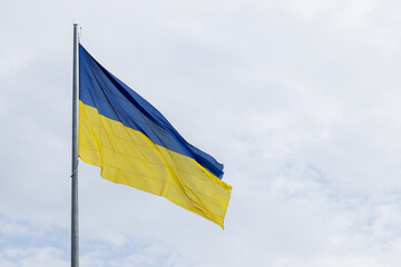 waving Ukrainian flag blue yellow national colors sign and symbols theme concept picture with neutral gray sky background