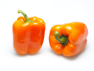 Two orange bell peppers on white.
