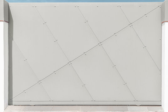 Textura de puerta de metal, con paneles de metal gris claro, con bordes suaves y con remaches visibles