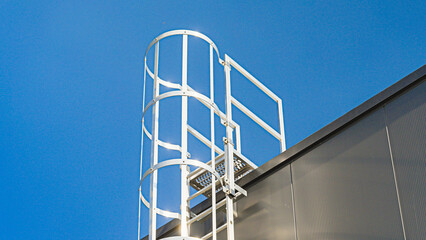 Outdoor fire escape ladder on wall of building in perspective.	