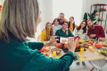 Photo of charming nice big family celebrating thanksgiving day tradition woman photographing friendly family indoors room home