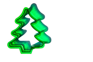 flat lay close-up of a green Christmas tree cookie cutter against a white background with copy space available