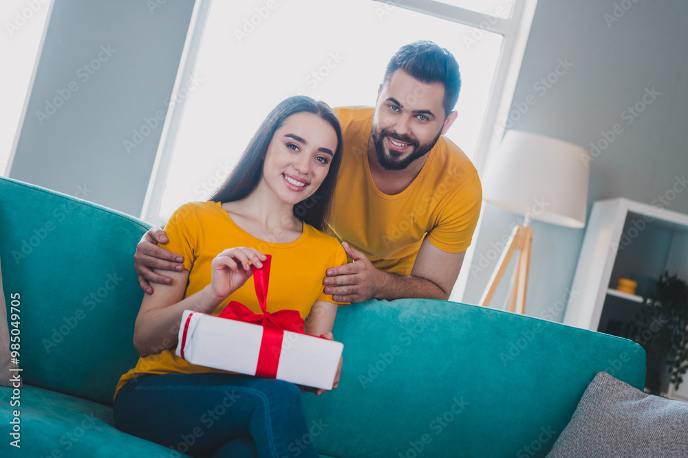 Poster Photo of two young partners embrace open giftbox free time modern interior apartment indoors