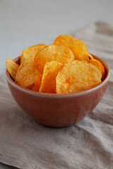 Homemade Flavored Cheese Potato Chips in a Bowl, low angle view.