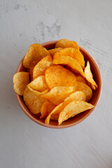 Homemade Flavored Cheese Potato Chips in a Bowl, top view.