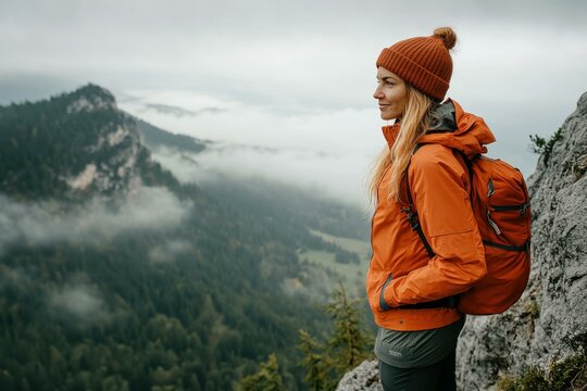 Young Woman in Orange Hiking Jacket in Misty Mountains - Outdoor Adventure and Exploration for Activewear Marketing
