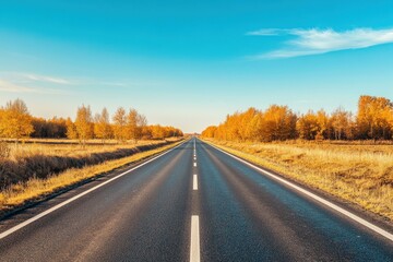 Scenic Road Under Clear Blue Sky With Vibrant Autumn Foliage - Ideal for Travel and Road Trip Promotions