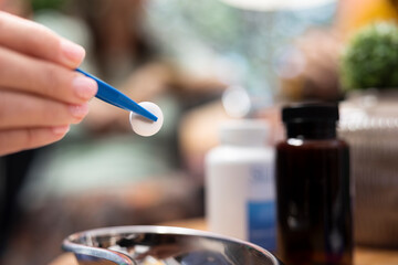 Professional caretaker dividing medicine pills and vitamins for senior man and woman, separating daily doses to ensure effective recovery treatment. Nurse putting capsules in bottles. Close up.