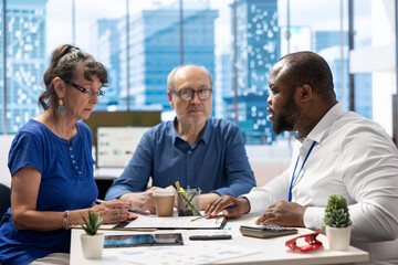 Senior citizens consulting a financial planner about retirement planning, ensuring their savings and investments are optimized for future financial stability. Planning to invest money.