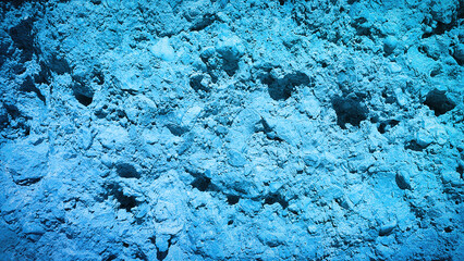 Vivid blue textured surface with natural stone elements, ideal for creative banners, digital wallpapers, or artistic backgrounds