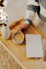 Cozy coffee moment captured in warm tones, featuring hand with cup of coffee, elegant vase, and notebook inscribed weekly planner