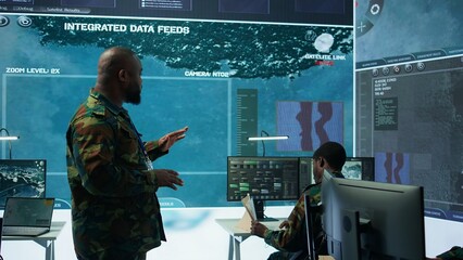 Military team operating in a high tech command post control tower, focusing on surveillance tactics...