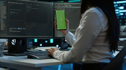 Worker overseeing data center using green screen mobile phone, ensuring system can handle networking tasks. IT expert in server room tracking network traffic with empty copy space smartphone, camera A