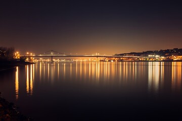 Night cityscape with bridge and reflections in the water