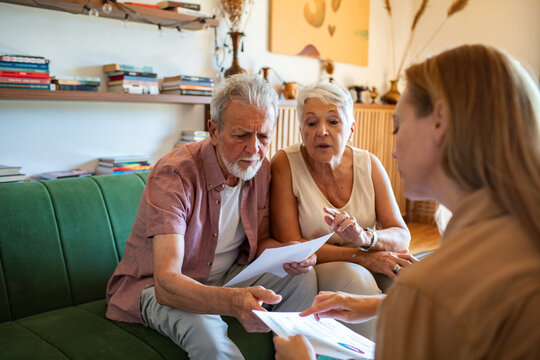 Worried senior couple talking to financial advisor at home