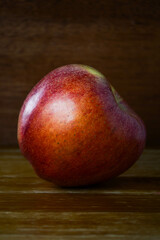 A single Scilate (trademark name Envy) apple on a wooden surface