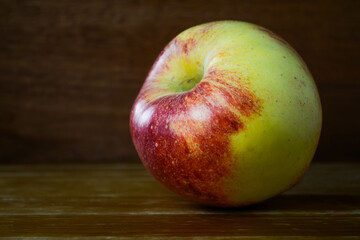 A single Scilate (trademark name Envy) apple on a wooden surface