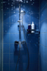 Shower with flowing water in the bathroom, shower head, image of water coming out, dark blue background.