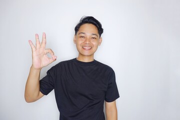 portrait of a handsome Indonesian man posing randomly wearing a black shirt on a white background isolated