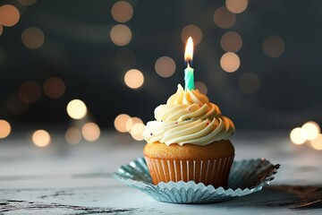 Delicious birthday cupcake with burning candle on blurred lights background. Cupcake has creamy frosting and colorful sprinkles. Perfect for celebrating special occasions with sweet treats.