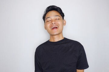 portrait of a handsome Indonesian man posing randomly wearing a black shirt on a white background isolated