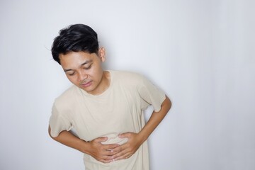 portrait of a handsome Indonesian man posing randomly wearing a Cream shirt on a white background isolated