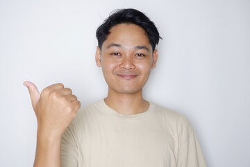 portrait of a handsome Indonesian man posing randomly wearing a Cream shirt on a white background isolated