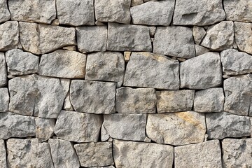 Obraz premium Close-up of granite stone wall with textured, stacked pattern. Rough, natural surface of rock, beige color, architectural background for construction, masonry, building design.