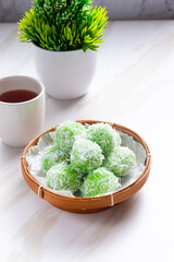 klepon or onde-onde made from glutinous rice flour and filled with brown sugar covered with grated coconut. Perfect for recipe, article, catalogue, commercial, or any cooking content.