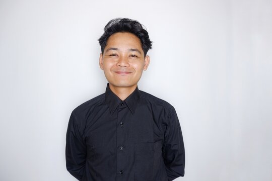 Portrait of a handsome Indonesian man wearing a plain black shirt with a random pose isolated on a white background