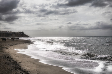 Nubes en el cielo sobre el mar con olas bañando la playa