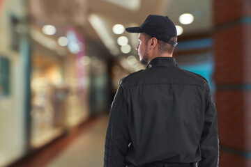 Security guard in shopping mall, back view. Space for text