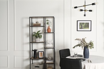 Stylish table setting with beautiful dishware and black chairs in dining room