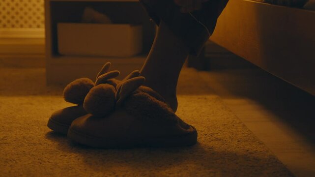 Comfort at home. Woman wearing warm slippers after getting out of bed, close up