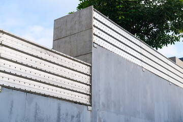 Modern concrete wall with metal panel accents, clean geometric lines, and industrial aesthetics,...