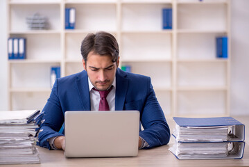 Young male employee and too much work in the office