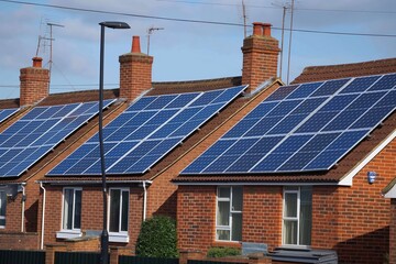 Fototapeta premium Solar panels on rear of terraced houses in UK. Photovoltaic system for renewable energy generation. Britain energy industry shift towards eco-friendly technology.