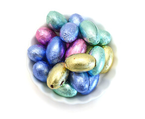 Chocolate easter eggs in colorful foil on white background
