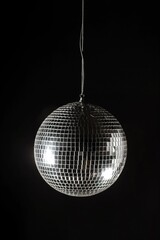 Silver disco ball hangs vertically on a black background. Shiny metallic sphere reflects light, creating a bright, fun atmosphere. Perfect for party decorations, club nights, and pub environments.