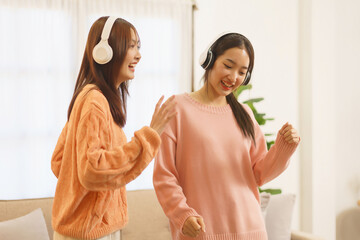 Friendship concept, LGBT lesbian couple wearing headphone to listening music and dancing together