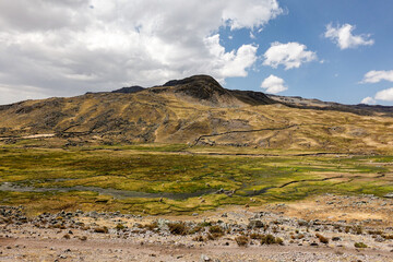 Paisaje de nubes, cerros y cesped en los Andes en el nevado de Ausangate en la Cordillera de Vilcanota en Cusco, Perú