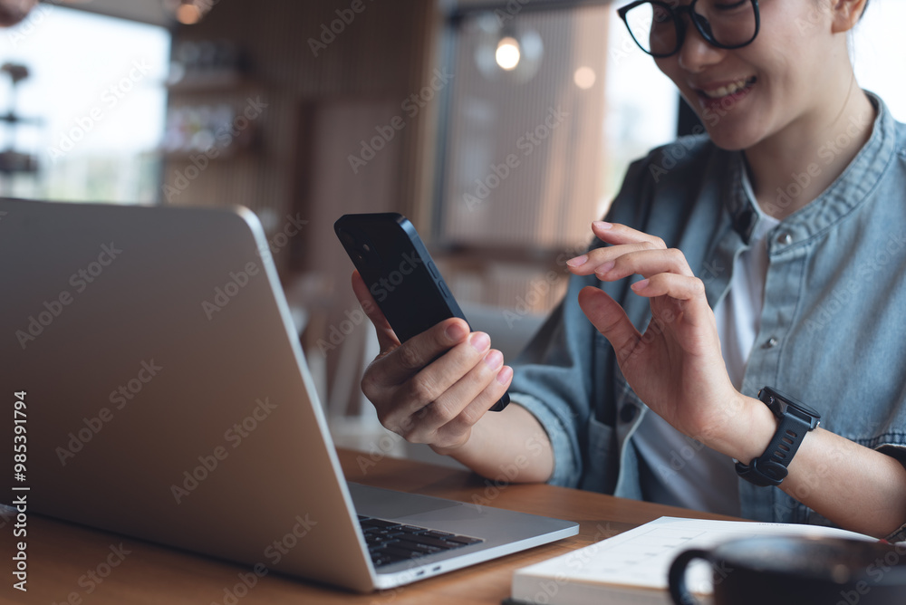 Wall mural business woman using mobile phone for video calling, online meeting during working on laptop compute