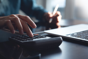 Accountant using calculator to calculate company finances at office. Bookkeeper inspector...