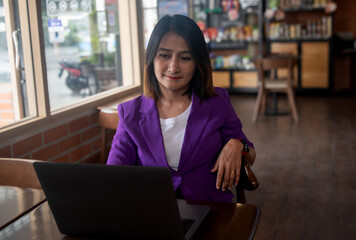 Businesswoman sitting in the cafe using laptop working account report finances, coffee break  time freelancers lifestyle concepts 