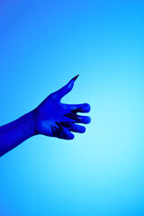 A blue witch hand with sharp red nails, set against a backdrop of blue fire. This eerie figure embodies demonic, ghostly, and zombie elements, perfect for Halloween horror and fantasy settings.