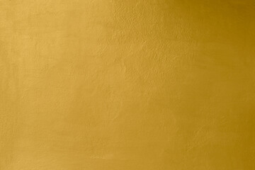 Gold wall texture background. Yellow shiny gold paint on concrete wall surface, vibrant golden luxury wallpaper