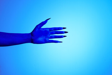 A blue witch hand with sharp red nails, set against a backdrop of blue fire. This eerie figure embodies demonic, ghostly, and zombie elements, perfect for Halloween horror and fantasy settings.