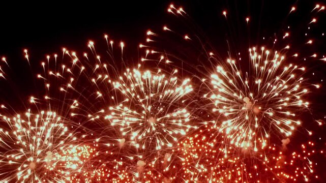 Colorful fireworks burst in slow motion, lighting up the night sky with festive brilliance, marking the joy and magic of Christmas celebrations.