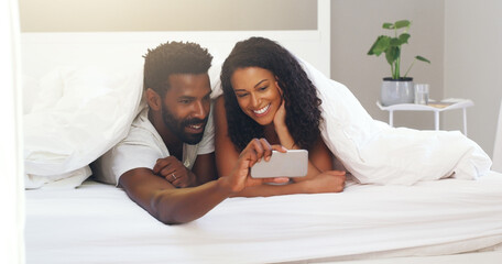 Obraz premium Black couple, selfie and bed with happy, smile and profile picture on wedding anniversary at morning. Bedroom, tech and people with post, social media and update with marriage, love and support